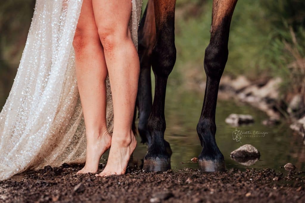 Beine einer Frau und die von einem Pferd