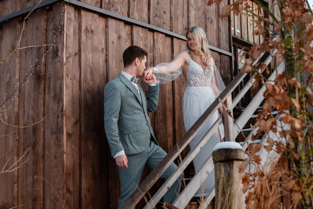 Ein Hochzeitspaar auf der Stiege im Schnee