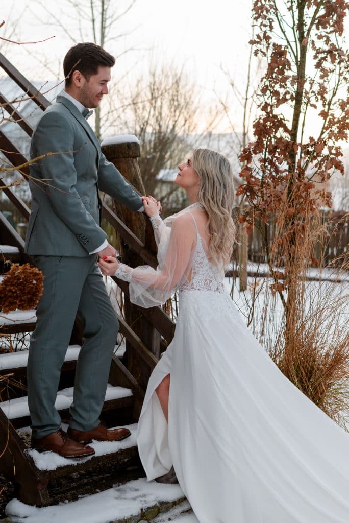 Ein Hochzeitspaar auf der Stiege im Schnee