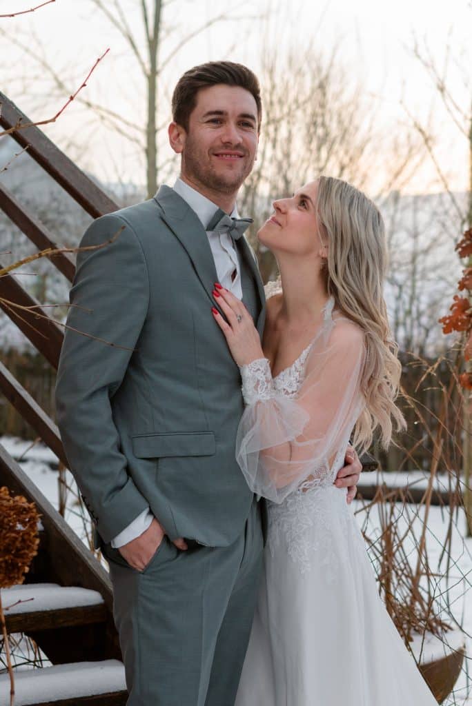 Ein Hochzeitspaar auf der Stiege im Schnee